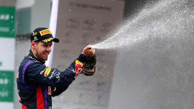 Ein Foto von Sebastian Vettel, der Champagner auf dem Podium versprüht. 